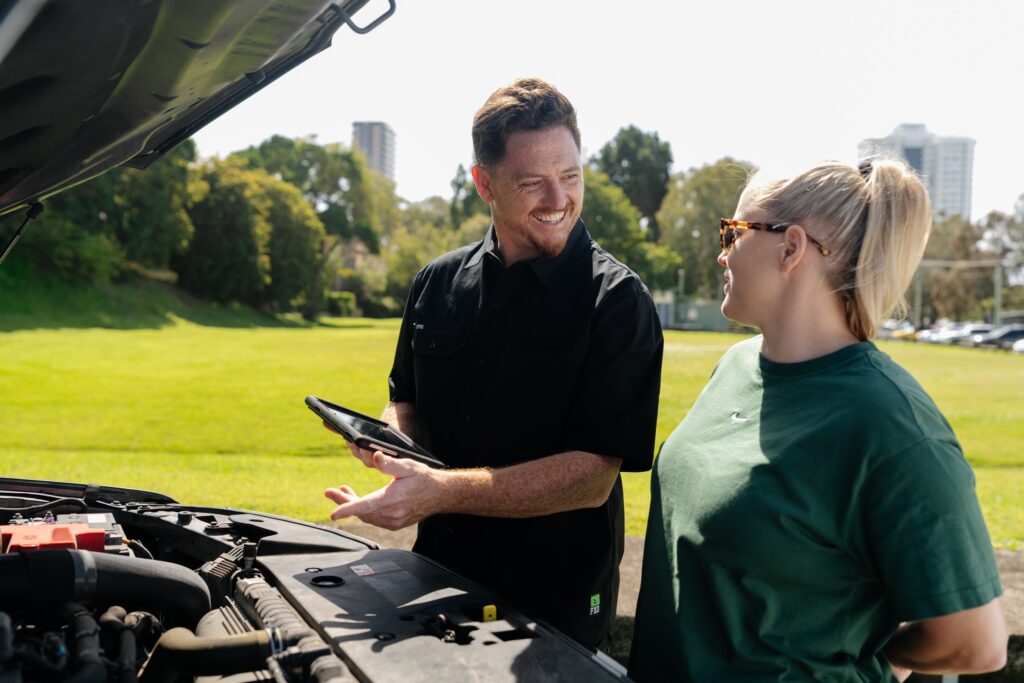 Inspector chatting with a customer at the bonnet during a Gold Coast safety certificate inspection