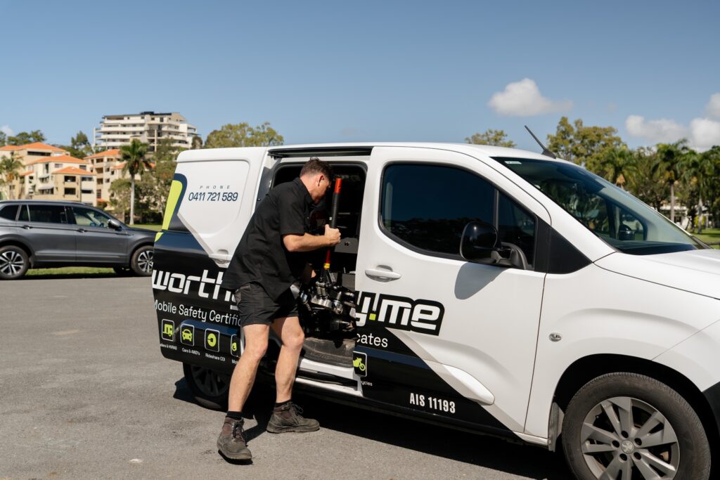 Roadworthy.me inspector unloading a trolley jack from the van for an at-home QLD safety certificate