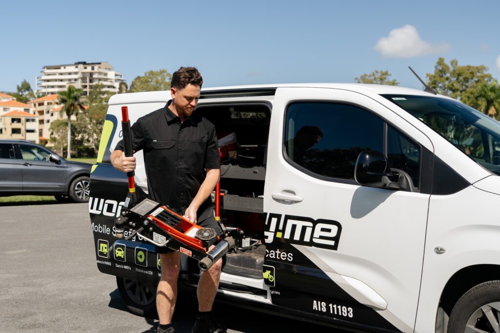 Roadworthy.me inspector unloading a trolley jack from the van – safety certificates in Mudgeeraba
