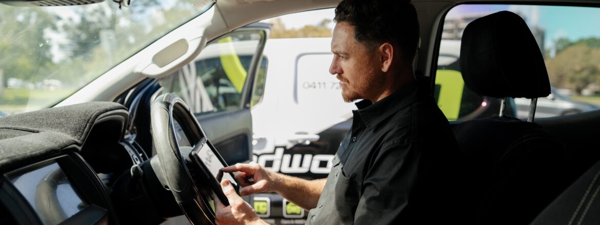 Inspector completing the QLD safety certificate checklist on a tablet inside the car